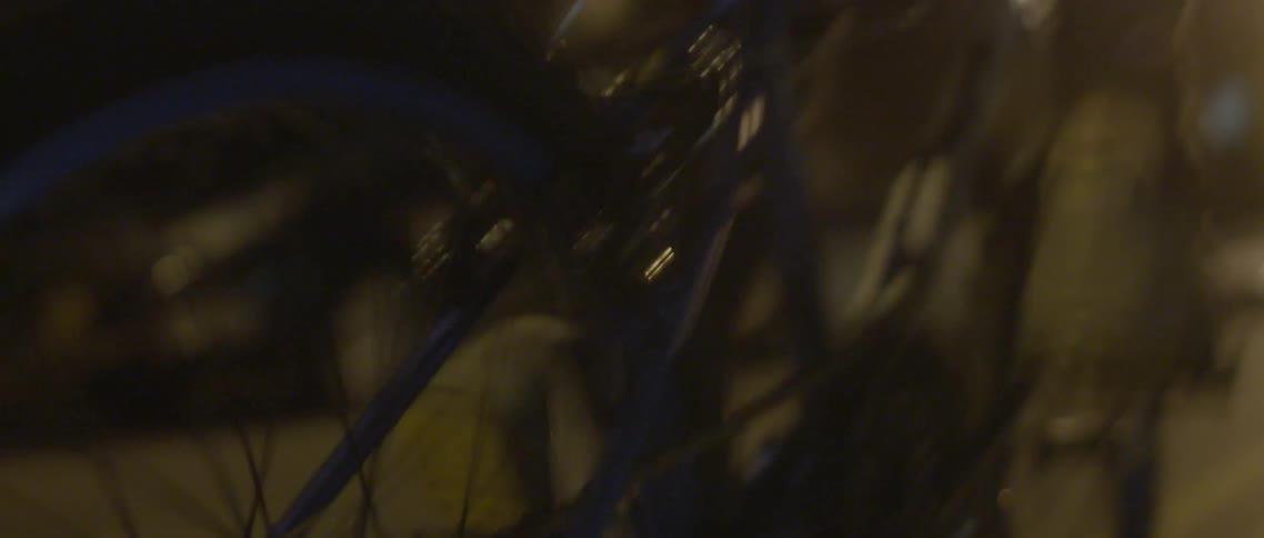 A bike is traveling down a street at night