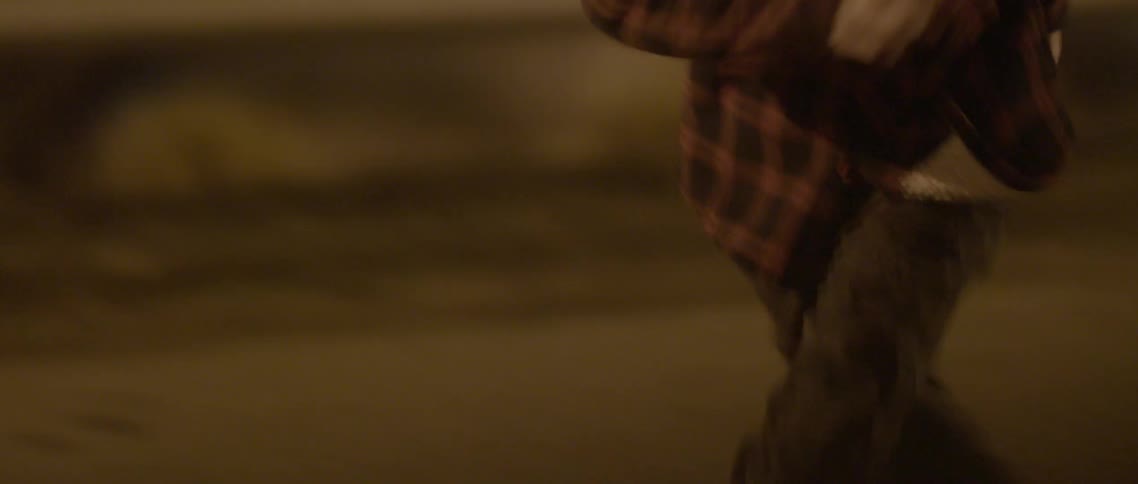A boy is running outside at night looking back