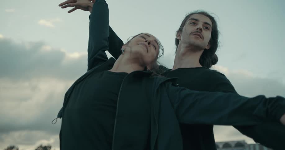 A man and woman raise their arms in the air as they dance
