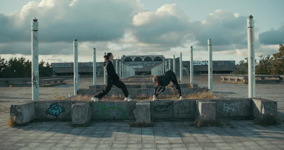 Two women outside talk and stretch
