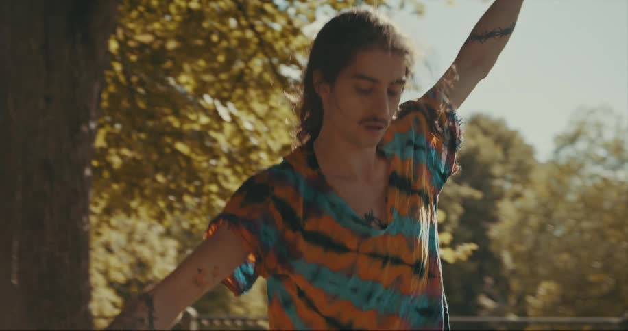Man balances on tightrope strewn around tree in backyard