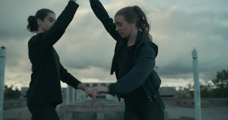A man and woman join hands as they dance and he twirls her around