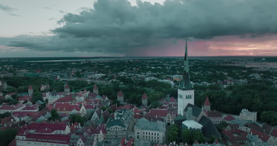 St olafs church stands above a town in estonia with a rain storm on the horizon