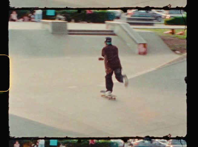 A young man pushes off riding his skateboard at a skatepark