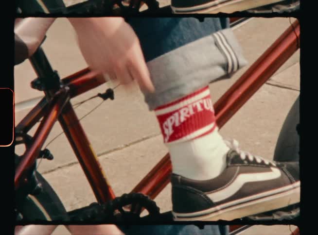 Footage of a person sitting on a bicycle is displayed
