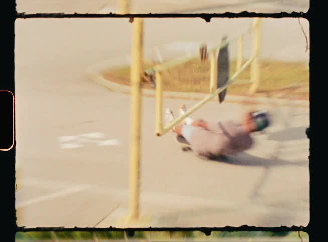 A man sits on his skateboard as he rides