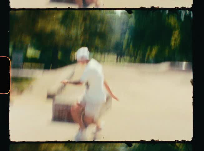 Vintage footage of a teenage boy skateboarding on a block of wood and falling of the skateboard
