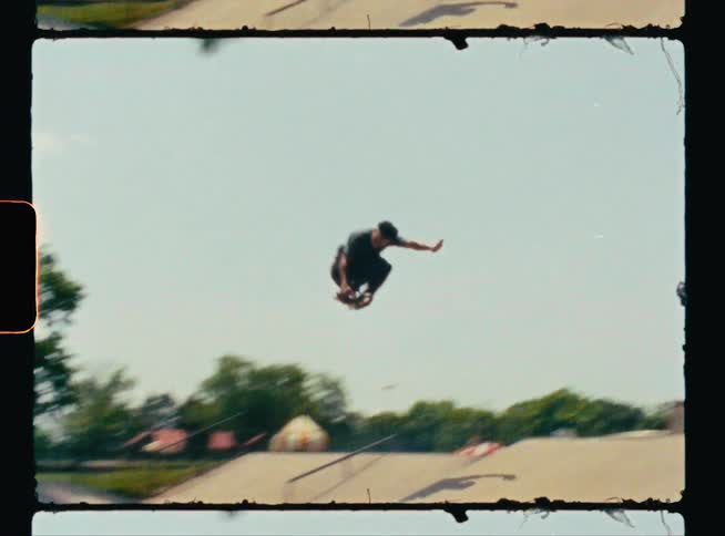A skateboarder flies through the air while jumping over a ramp