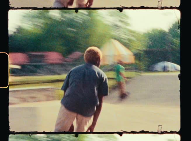 Man with blue shirt and white pants skateboards in skatepark