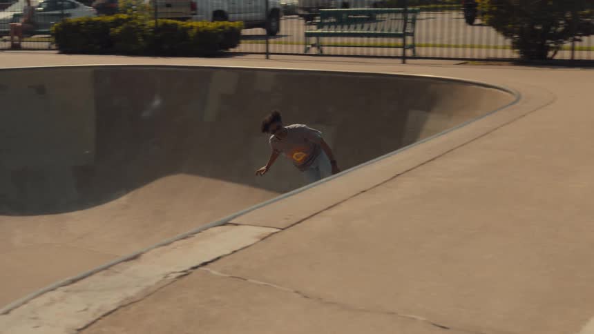 A man rides his skateboard around a skate park