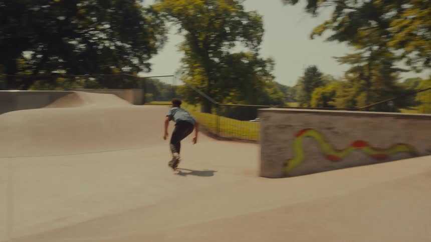 A man rides a skateboard through a skate park