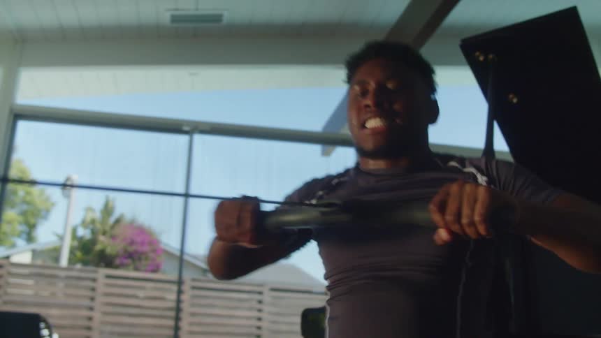 A man is working out on a machine during the day