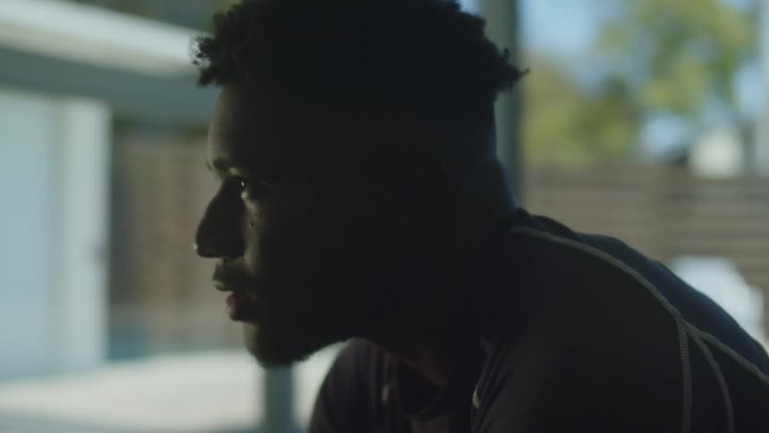 A man is sitting in a room near a window