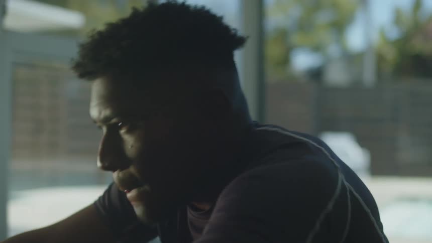 A young black man is working out in the middle of the day