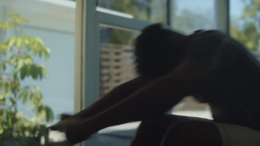 A man uses a rowing machine to work out at home