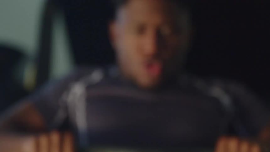 A man is sitting in a rowing machine and working out hard