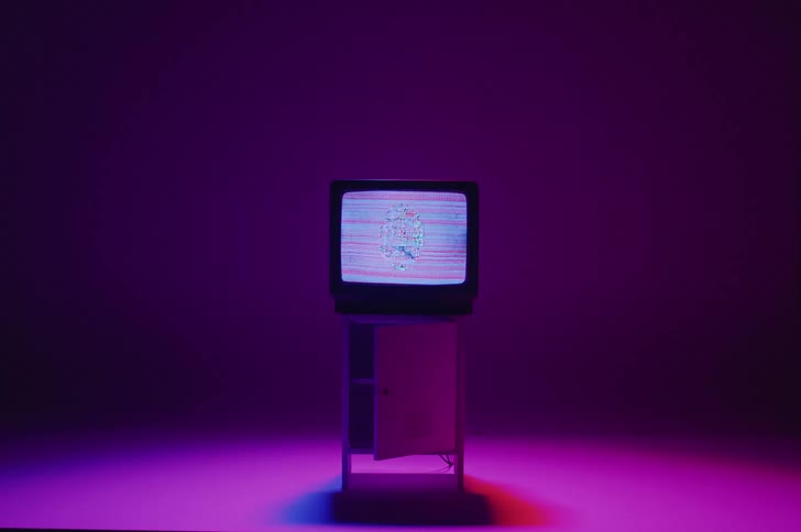 Television shows noisy signal as colored lighting casts shadow on the floor