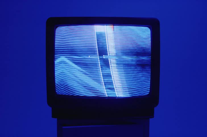 A television with static is displayed indoors