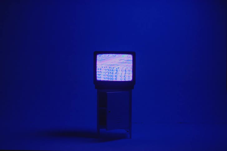 A vintage television with a fuzzy screen on a stand