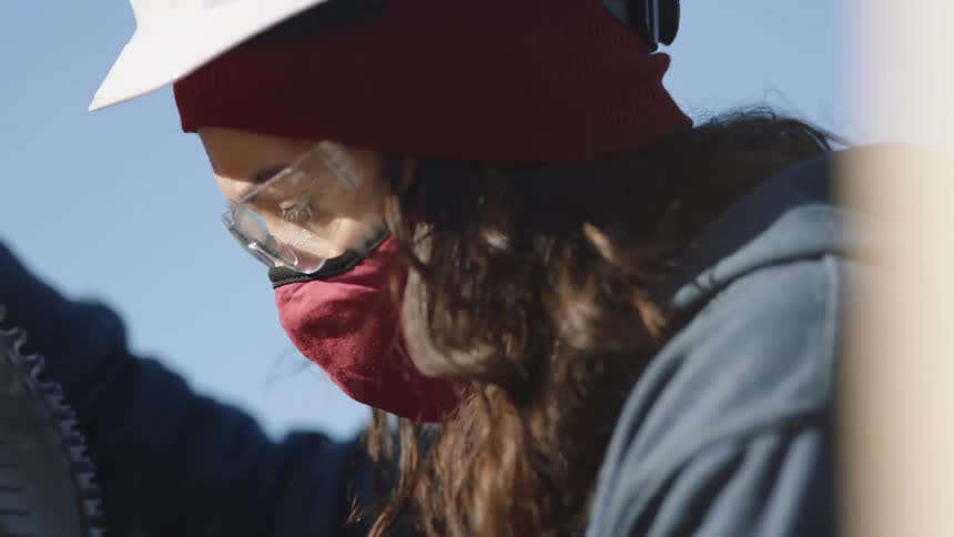 A construction employee is working outdoors with machinery