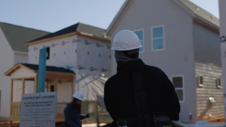 Workers are outside doing construction in the middle of the day time