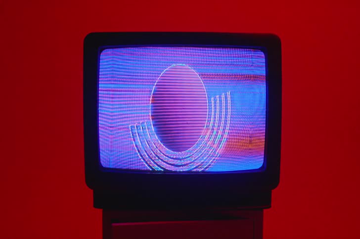 A vintage television with a fuzzy screen sits on a table