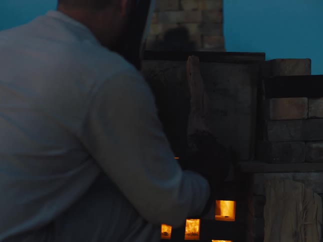 A man burns wood in a wood stove