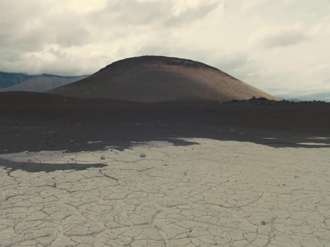 Flat arid plain borders woods and hills on an overcast day