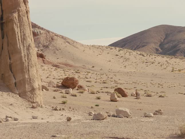 A view of rocks in a desert during dusk is displayed