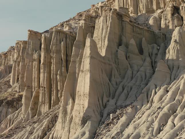 Sun shining on weather eroded rock formations that look like columns