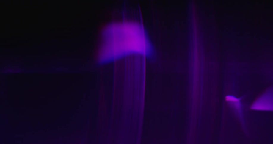 A ribbon of light floats and moves between colorful lines and webs against black