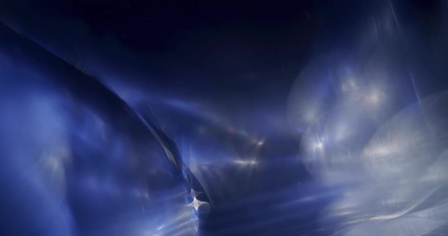 A white and blue glow fills the darkness as wisps turn to shapes as they move across the organic realm