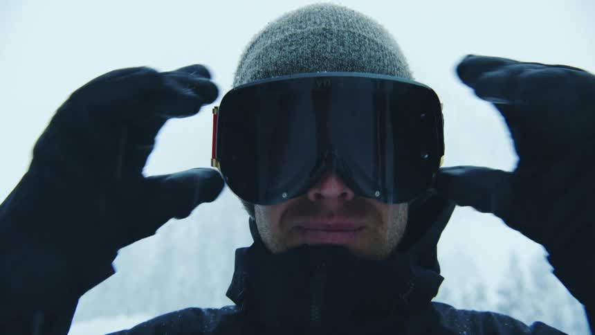 There is a white man that is standing outside in the winter time