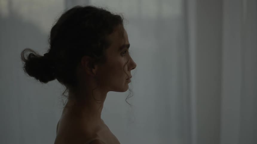 A woman is standing in a room near a wall
