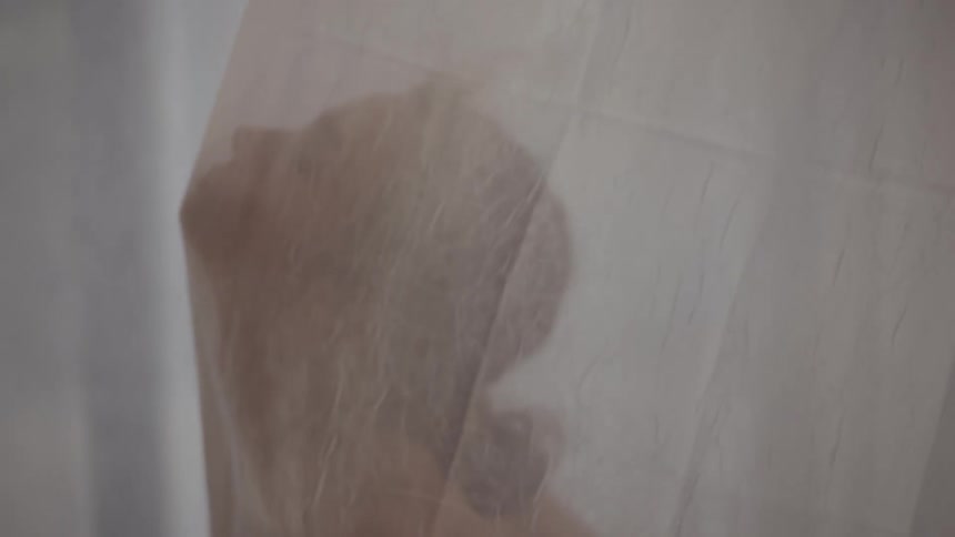 A woman dances using a sheer fabric curtain as a prop