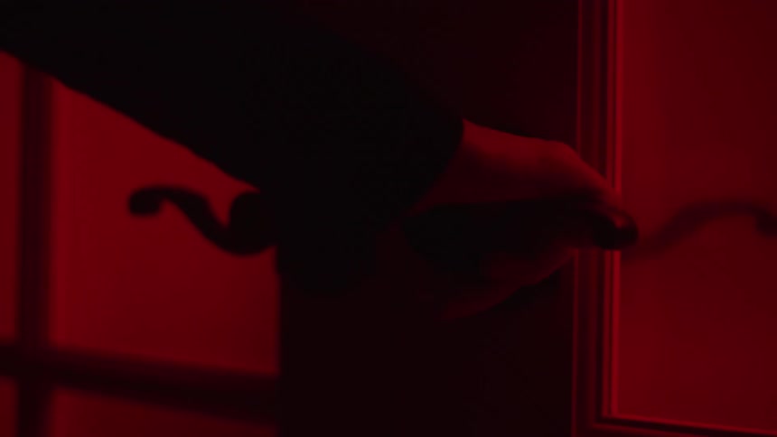 A person is turning a handle to open a door