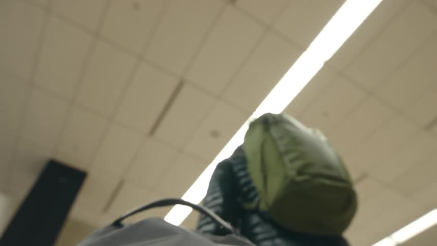A man in an airport picks up his bag and walks away