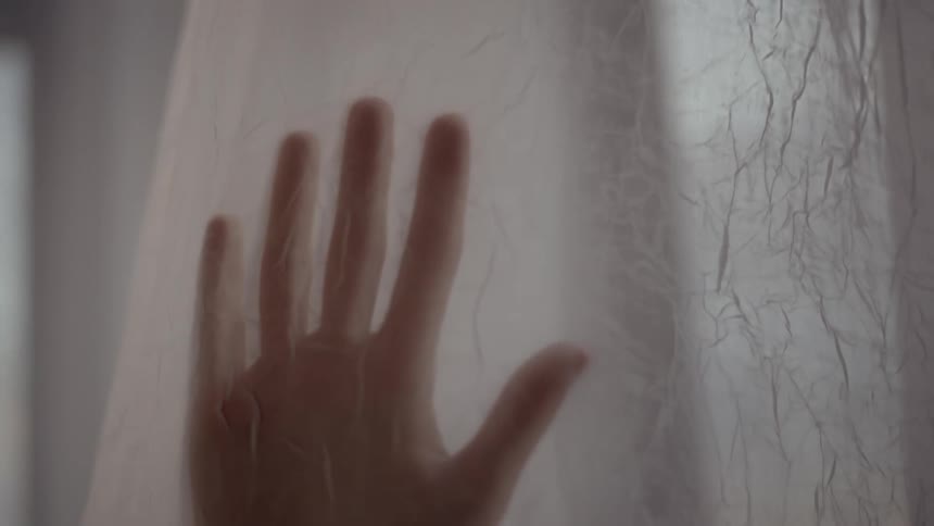 A womans hand as she runs it down drapes
