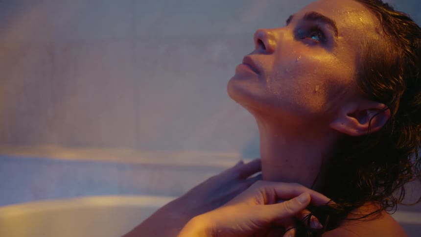 A woman with wet hair relaxing in a bathtub