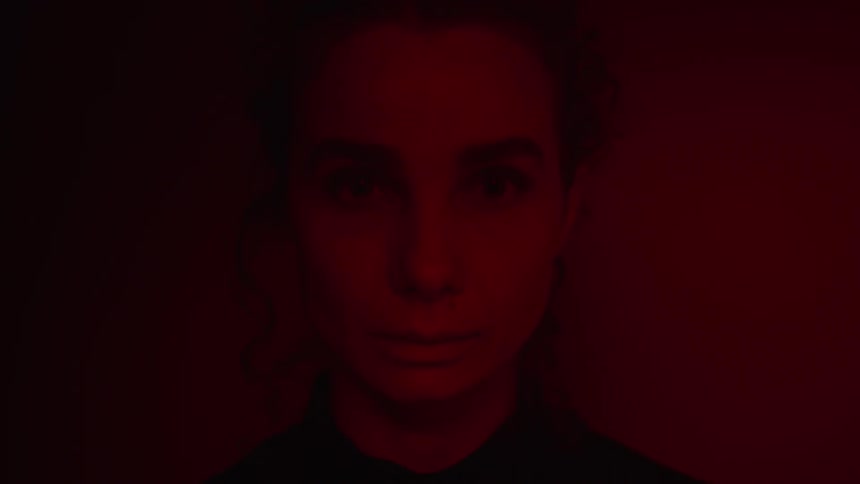 Close up view of a womans face in the dark is displayed