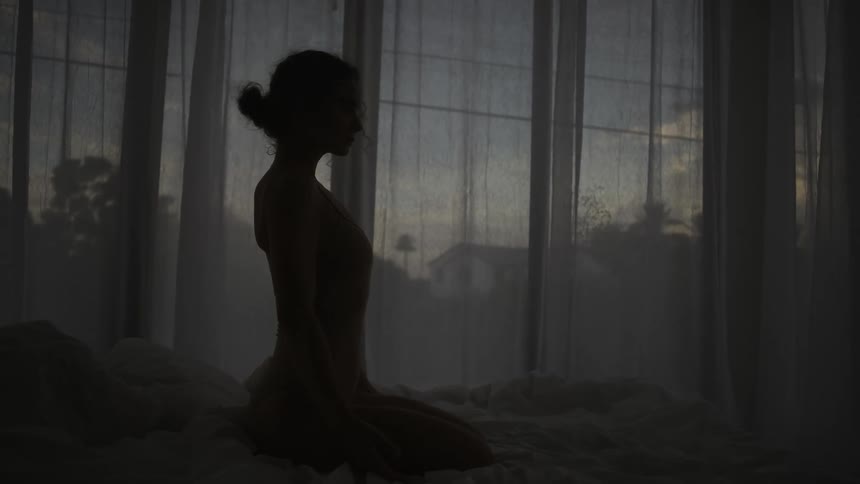 A woman is dancing by the window