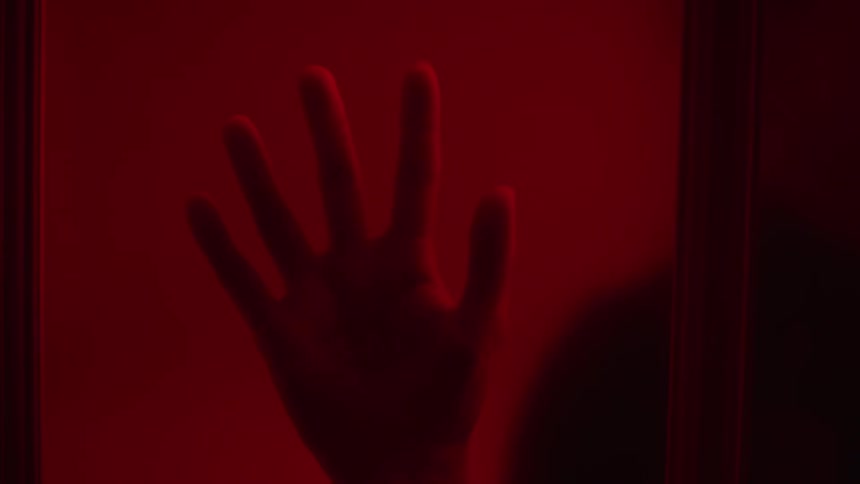 There is a person putting there hand on the window