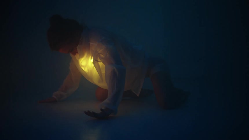 A young white woman is dancing at night time