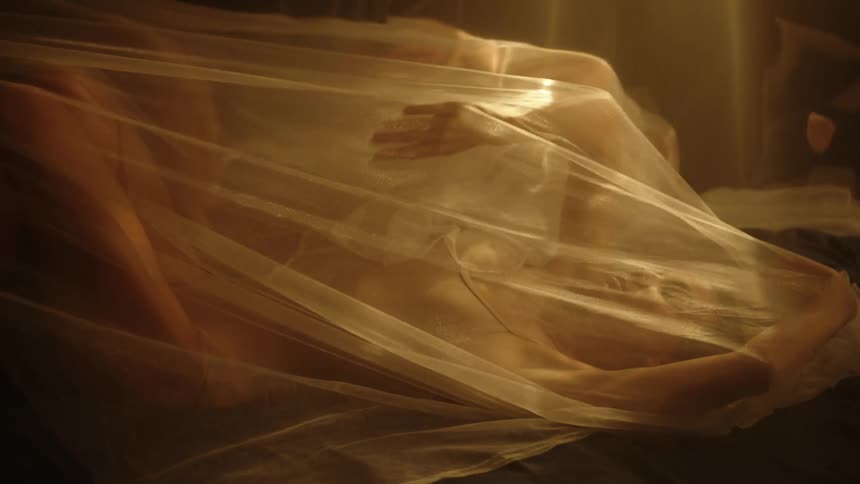 A woman moving her arms beneath a billowy piece of fabric