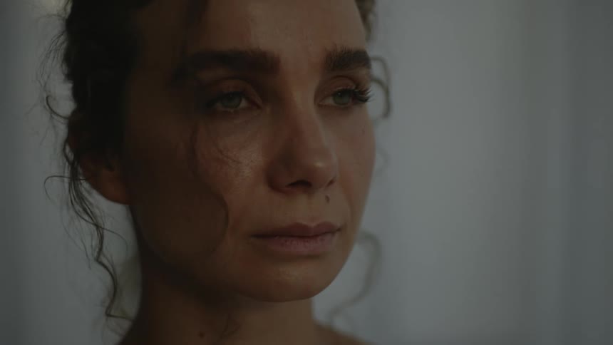 The face of a blinking woman gazing at something out of frame