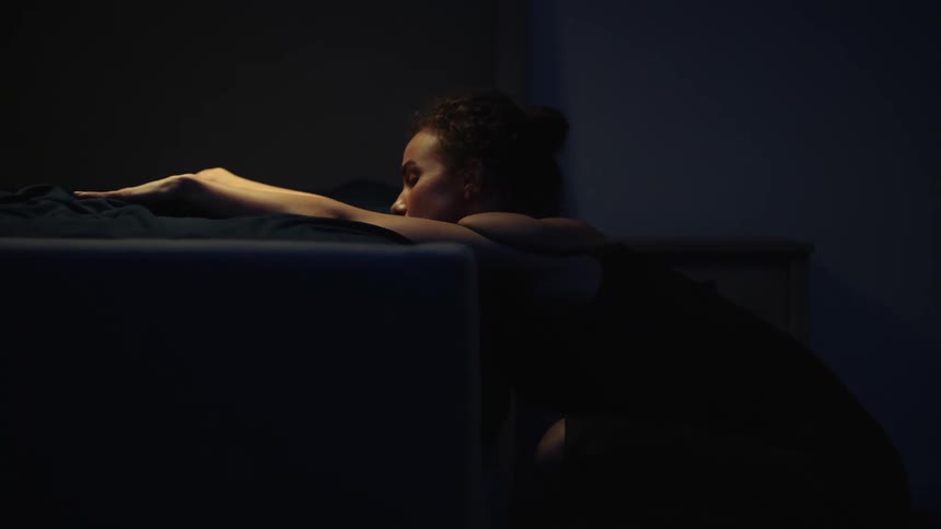 A female dancer with muscled arms outstretched sinks down to the floor