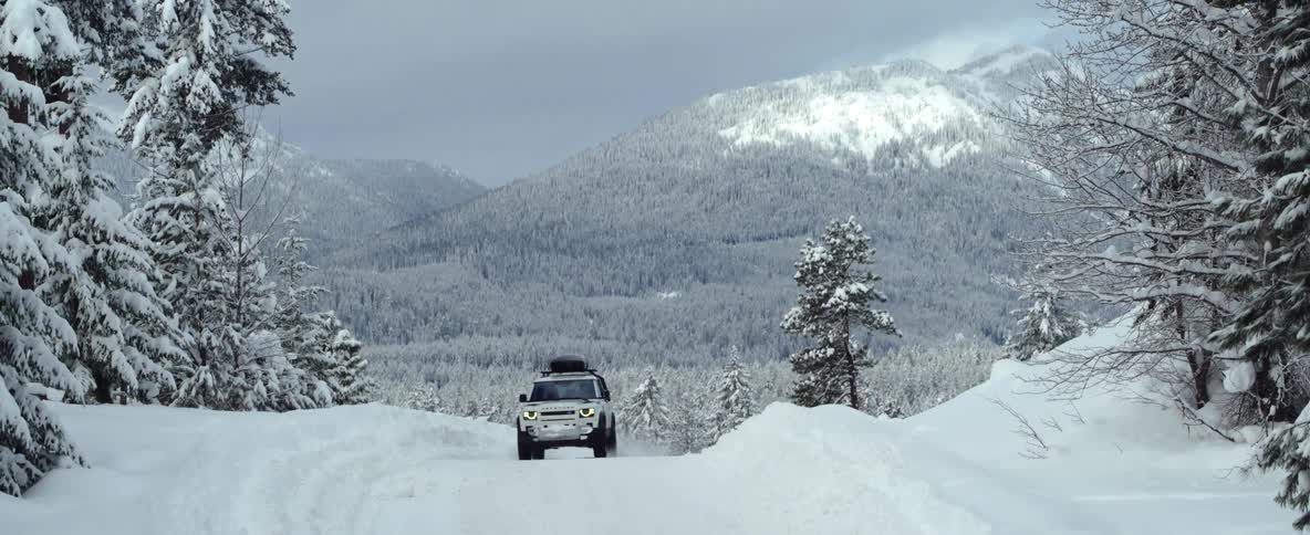 A car is driving outside down the road in the winter time