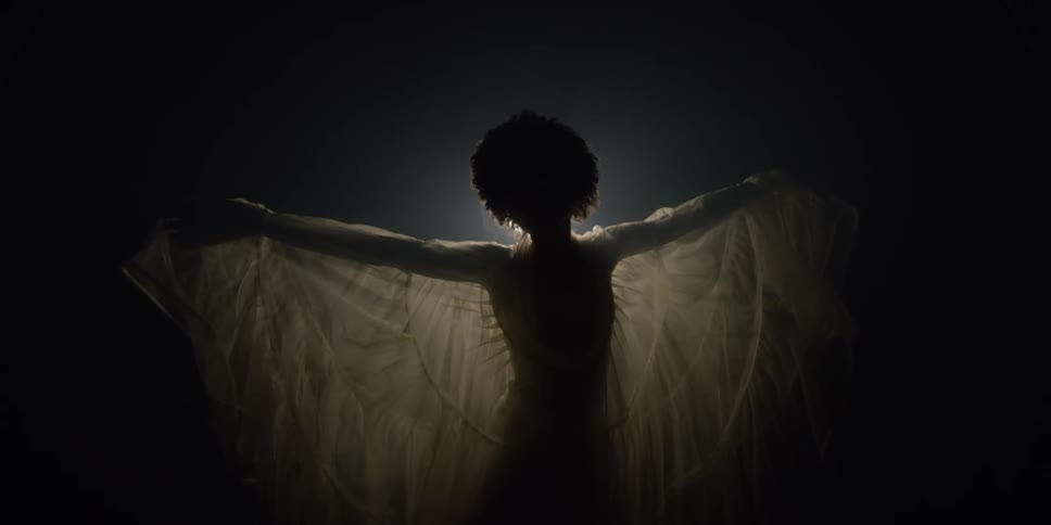 A woman is dancing outdoors during the night time