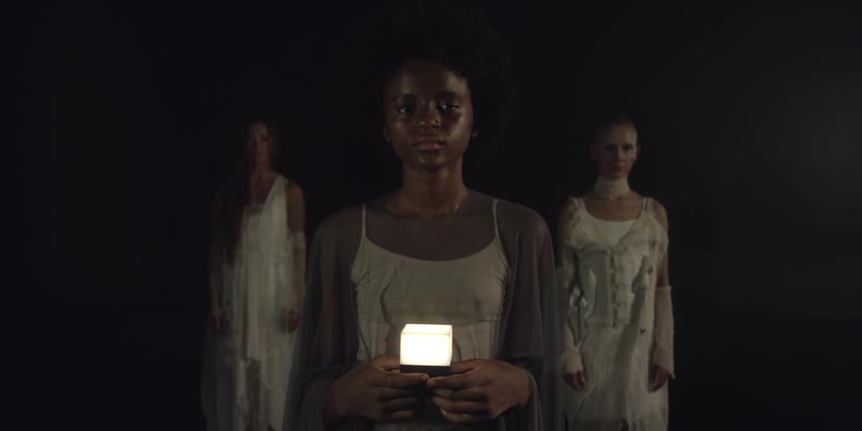 A woman is holding a glowing cube