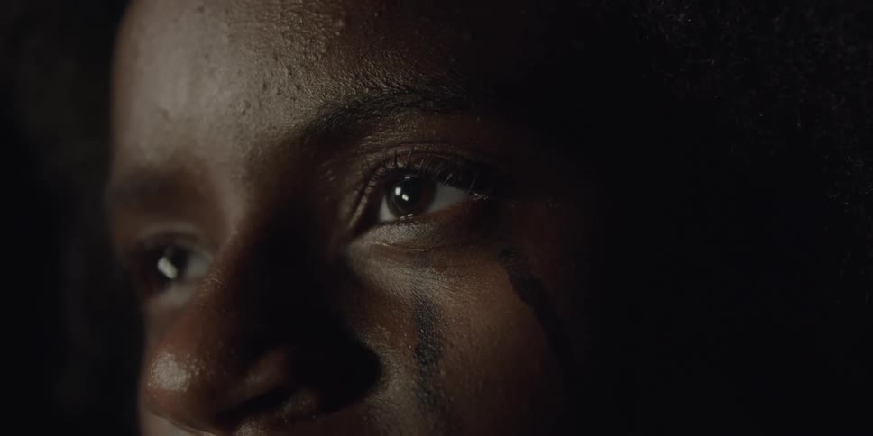 Rain drops fall on a woman's face as she blinks the drops away